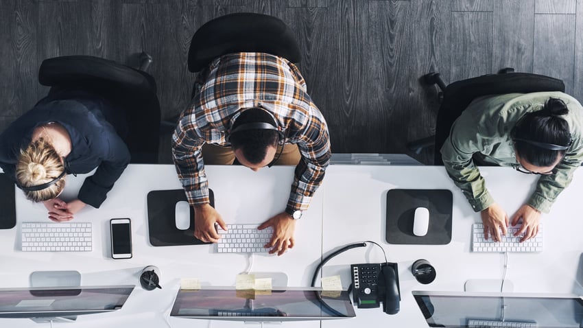 Foto do alto de um grupo de agentes de call center trabalhando em um escritório