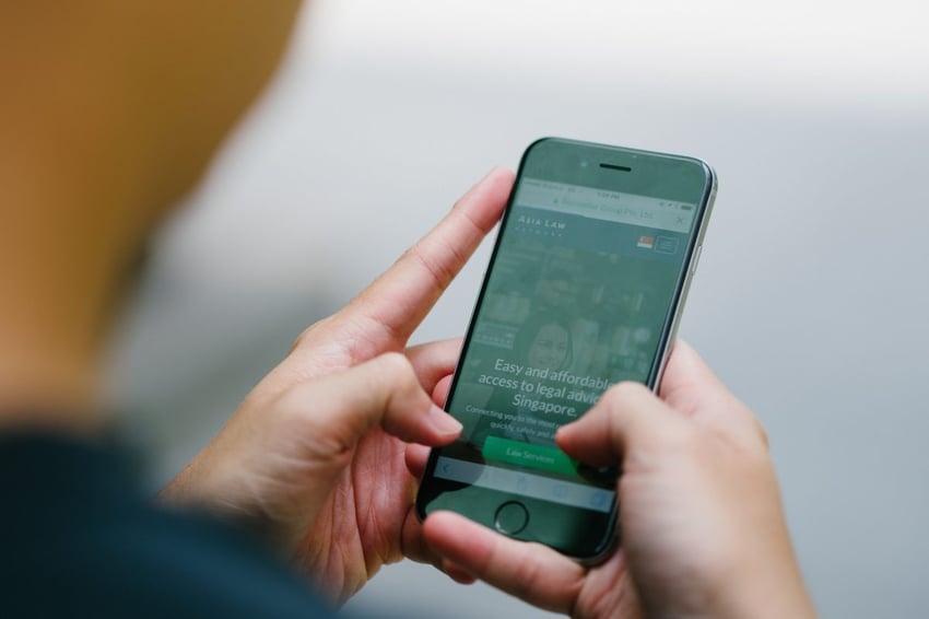 Aplicativo telefônico da Asia Law com alguém segurando o telefone